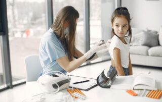 Female doctor performing a well-child checkup on a young girl using a stethoscope in a pediatric clinic.