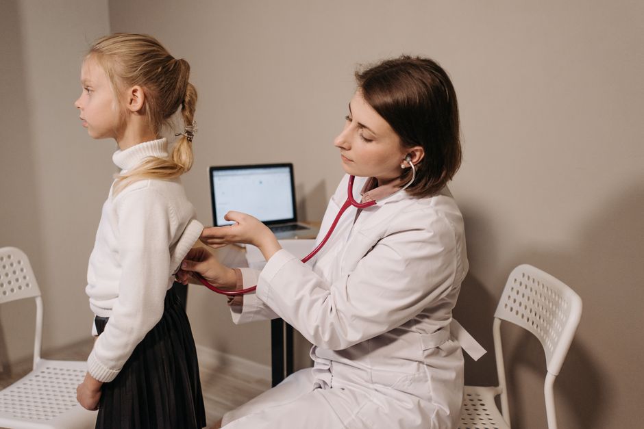 Doctor using stethoscope to examine a young girl during a pediatric checkup at a North Idaho family medicine clinic