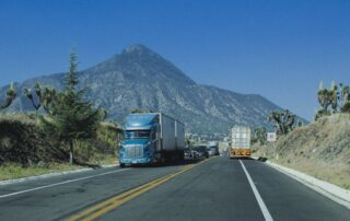 Commercial truck driving on a highway through North Idaho mountains