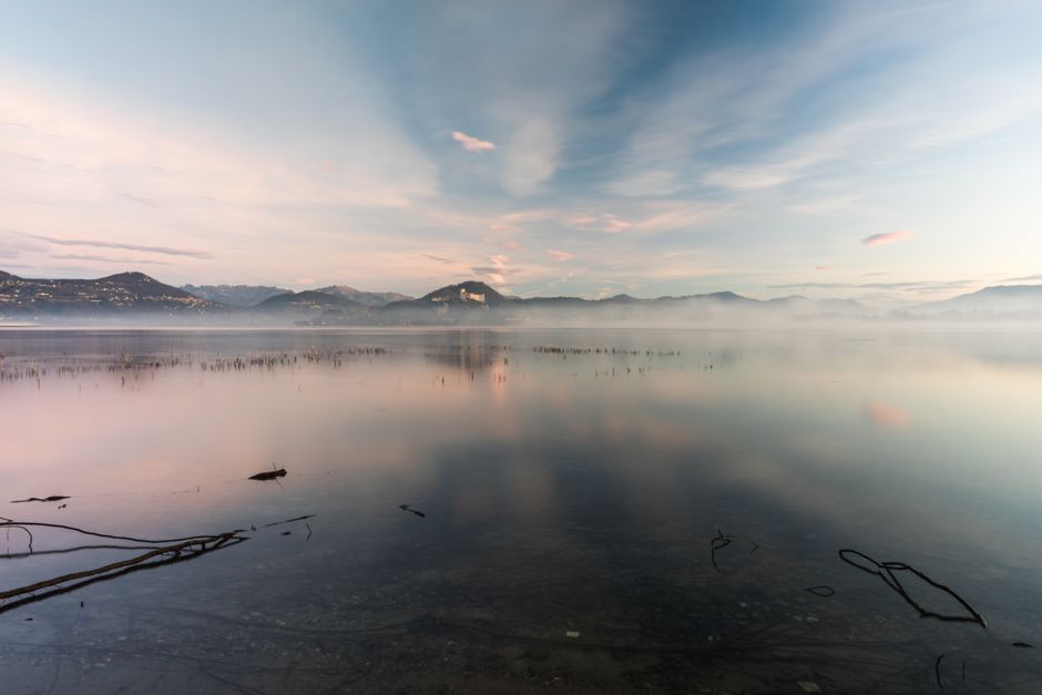 Calm morning light over a lake and forested mountains in North Idaho