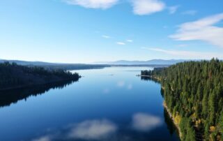 Calm lake and forested mountains near Sandpoint, Idaho on a clear day