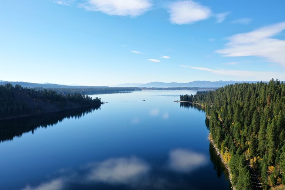 Calm lake and forested mountains near Sandpoint, Idaho on a clear day