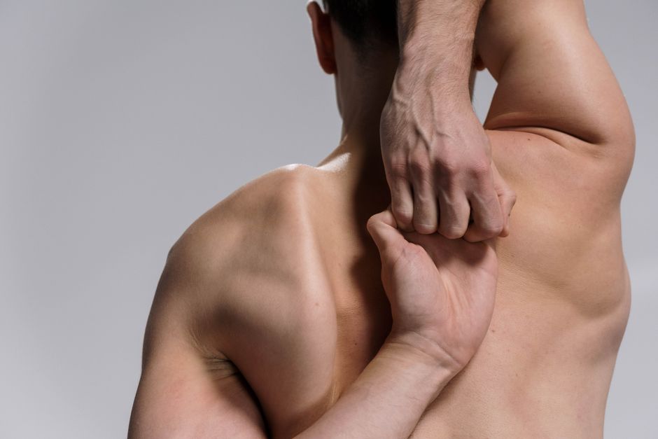 Person receiving gentle hands-on back and shoulder treatment in a calm setting