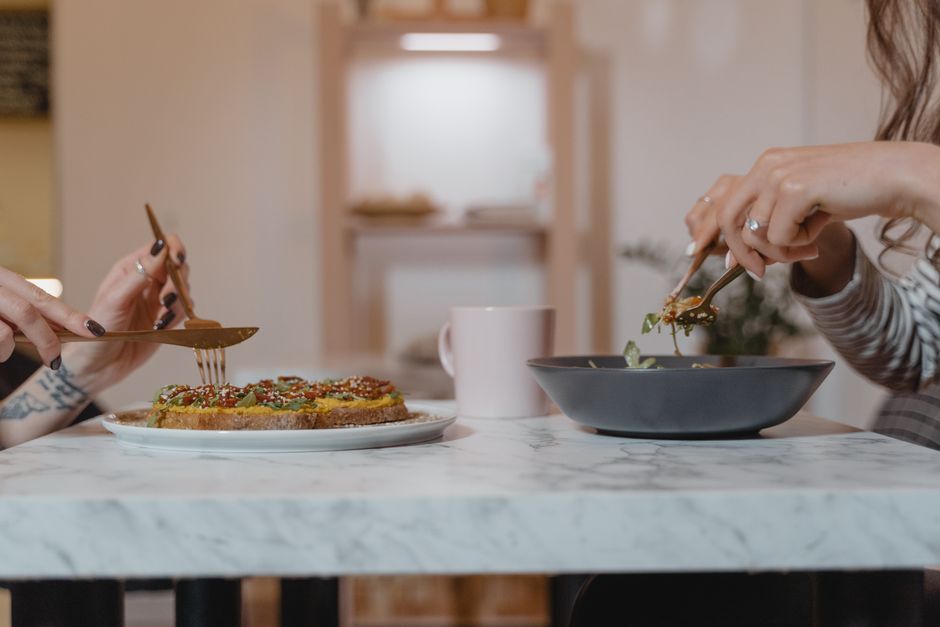 Small group of adults sharing a healthy meal around a wooden table